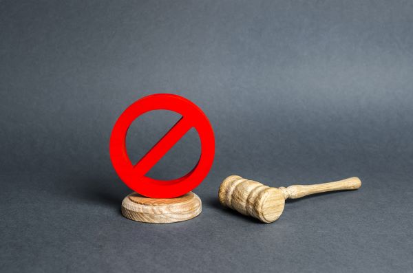 Image of a judge's gavel and veto or objection sign as a concept for litigation articles.